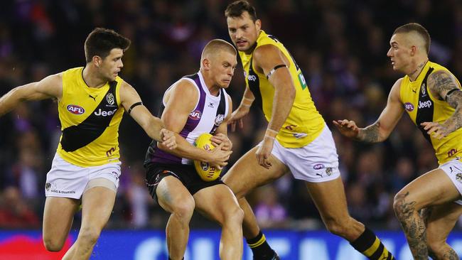 St Kilda’s Sebastian Ross gathers the ball from Trent Cotchin (left) at Etihad Stadium last year. Picture: Getty Images