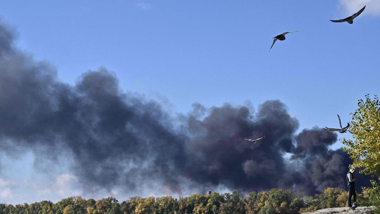 Birds fly as smoke rises over Dnipro river after several Russian strikes hit the Ukrainian capital of Kyiv on October 10, 2022, amid the Russian invasion of Ukraine. (Photo by Genya SAVILOV / AFP)