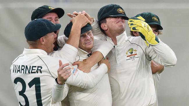 Australia's Steve Smith is mobbed by his teammates after his classic catch. Picture: AFP