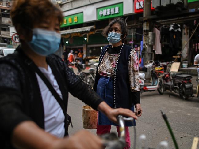 People wearing face masks visit a market in Wuhan, in China. Picture: AFP