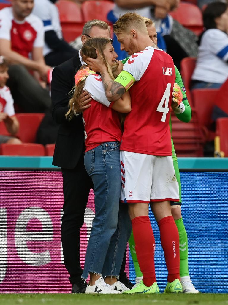 Eriksen’s Sabrina Kvist Jensen is consoled by Simon Kjaer of Denmark while he received medical treatment.