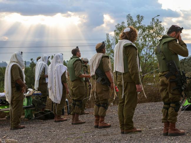 Israeli soldiers wearing tefillin (phylacteries), small black leather boxes containing scrolls inscribed with verses from the Torah, pray in the north of Israel near the border with Lebanon on October 15. Picture: AFP