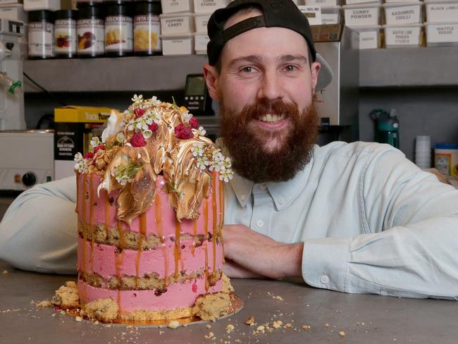 Baker Andy Bowdy with one of his signature loaded cakes. Picture: Adam Ward