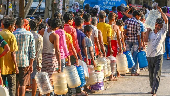 People wait to fill up with water from a government supply tanker during a high temperature heatwave, at Chilla Village, near New Delhi, India. Picture: Raj K Raj/Hindustan Times via Getty Images