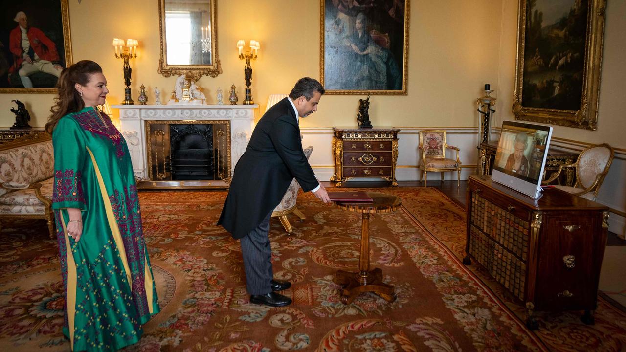 Queen Elizabeth II is seen on a screen via videolink from Windsor Castle during a virtual audience to receive the Ambassador of Jordan, Manar Dabbas (C) accompanied by Muna Abuhassan (L) at Buckingham Palace on February 17. Picture: Aaron Chown / AFP