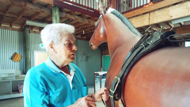 Bob Hood fits the bridle to "Ibbo" - the horse statute at the Lawrence Museum