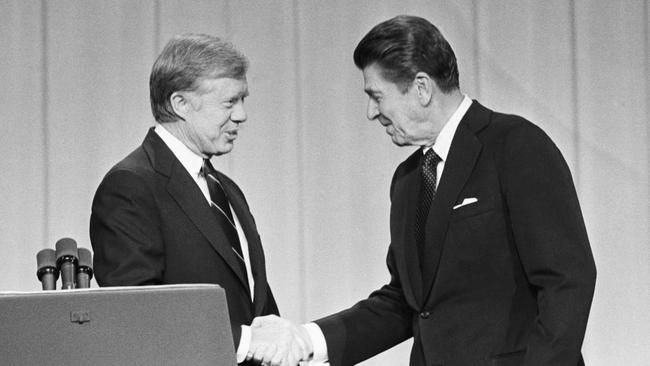 President Jimmy Carter and his Republican challenger, Ronald Reagan, shake hands as they greet one another before their debate on the stage of the Music Hall in Cleveland, Ohio.