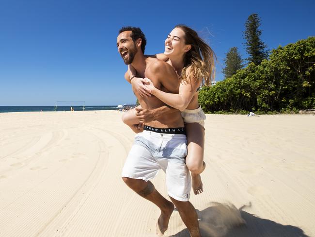 Hold See Courier Mail Pic Desk!Lucas Faria 32, and Stephanie Kunde 23, soak up the sunshine welcoming Queenslanders to springtime at Moffat Beach. Photo Lachie Millard