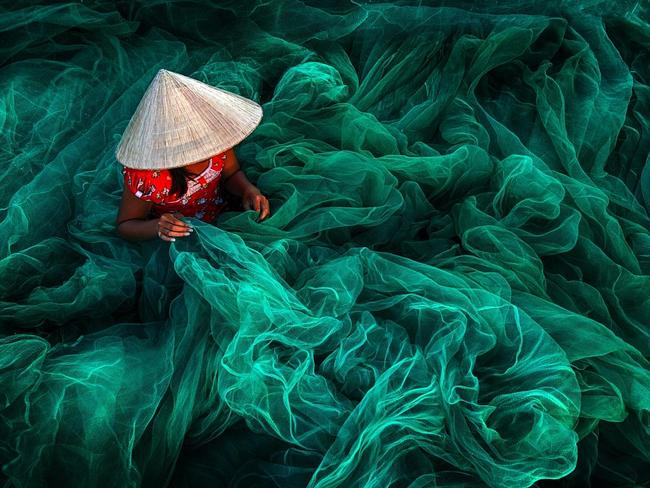Phan Rang Fishing Net Making ... In a small village in southern Vietnam near Phan Rang, a woman wearing a typical cone hat is creating a fishing net in their traditional manner. The manufacturing of handmade nets is still a typical Vietnamese activity for women which they carry on while their husbands are out fishing. Location: Vietnam. Picture: Danny Yen Sin Wong (MY)/Siena International Photo Awards 2016