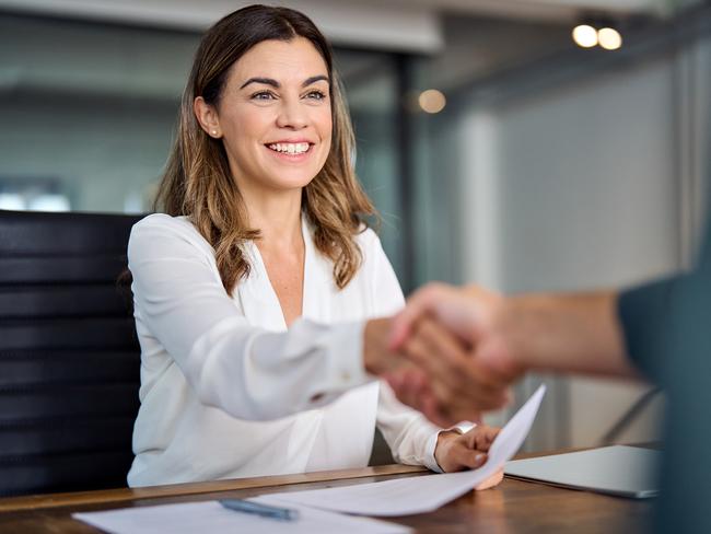 Happy mid aged business woman manager handshaking at office meeting. Smiling female hr hiring recruit at job interview, bank or insurance agent, lawyer making contract deal with client at work.