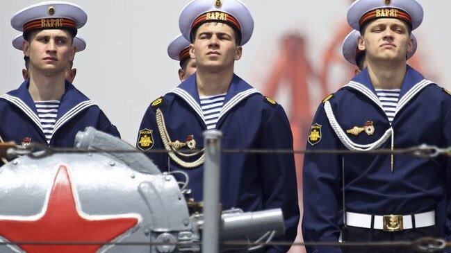 Russian sailors stand at attention on board their ship as it leaves Shandong province in China, Picture: Reuters.