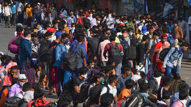 Migrant workers gather outside Dharavi slums to board a bus to take them home. Picture: AFP