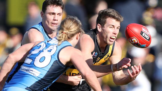 Glenelg’s Chris Curran handballs under pressure. The premiership captain will join forces with Jack Trengove at Prince Alfred OC next year. Picture: Sarah Reed