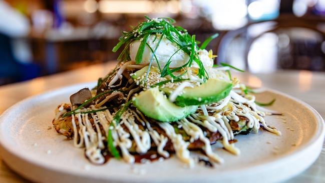 Okonomiyaki topped with a pile of sesame marinated mushrooms, crisp bean sprouts, green onion and avocado slices and a poached egg – a light but filling brunch or lunch option at Spencer’s. Picture: Linda Higginson