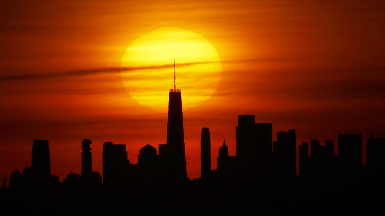 The sun rises behind the skyline of lower Manhattan and One World Trade Center. Picture: Gary Hershorn/Getty Images