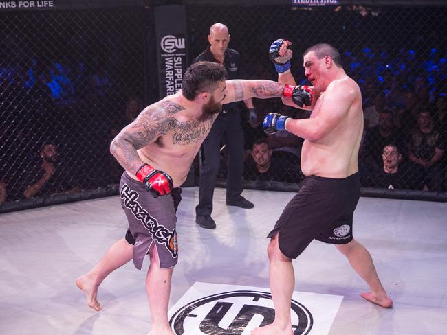 Ben Sosoli lands a big punch on Mike Turner during their Diamondback Fighting Championship heavyweight title fight at Adelaide Oval. Picture: Justin White. Ben Harvy