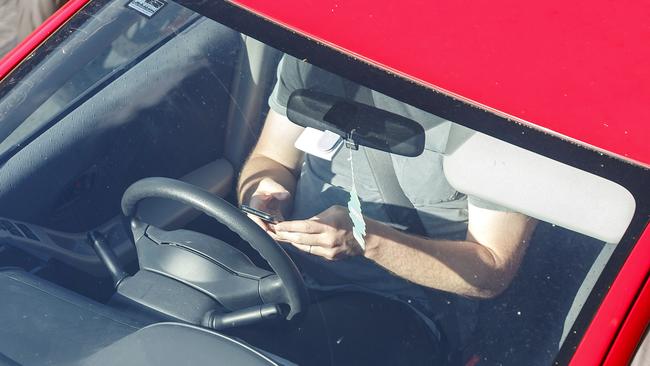 A drivers is caught using their phone in Brisbane. Picture: AAP / Josh Woning