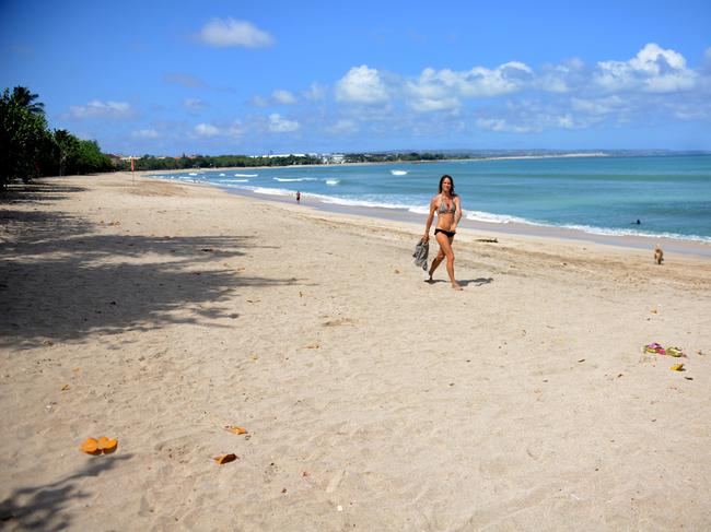 A woman walks along an empty Kuta beach in Bali. Picture: AFP