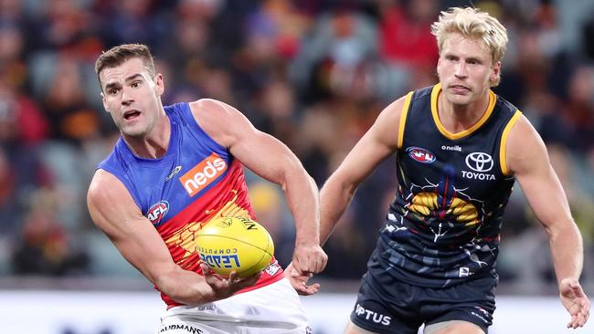 Jack Payne of the Lions handpasses the ball away from Billy Frampton of the Crows. Picture: Sarah Reed