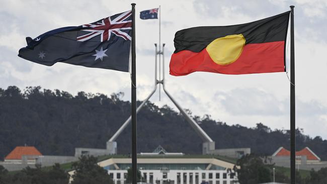 The Australian and Aboriginal flags fly side by side outside Parliament House in Canberra. Picture: Martin Ollman