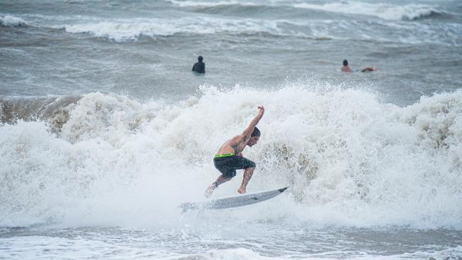 A surfer hangs ten at the Nightcliff Beach, Darwin. Picture: Pema Tamang Pakhrin