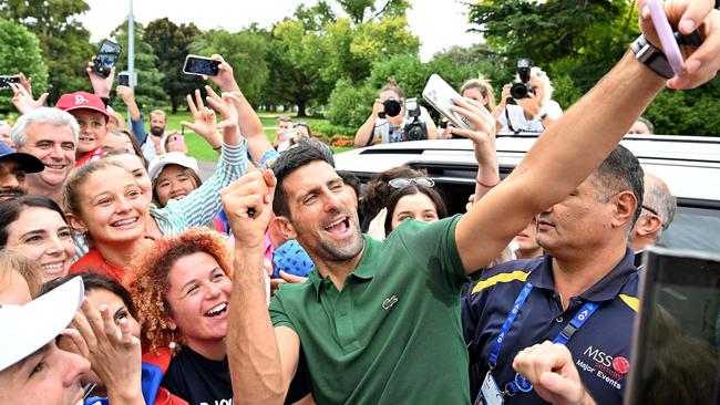 Serbia's Novak Djokovic gets selfies with his supporters outside the Government House  in Melbourne on January 30, 2023, after winning the Australian Open tennis tournament's mens' singles final against Greece's Stefanos Tsitsipas. (Photo by SAEED KHAN / AFP) / -- IMAGE RESTRICTED TO EDITORIAL USE - STRICTLY NO COMMERCIAL USE --