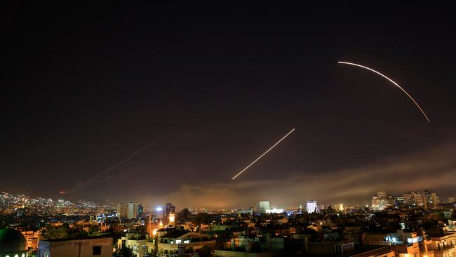 Missiles streak across the Damascus skyline as the US launches an attack on Syria targeting different parts of the capital on Saturday. Picture: AP /Hassan Ammar.