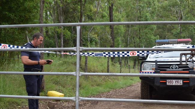 Imbil police senior constable Bill Greer guards the entrance to an Amamoor property.