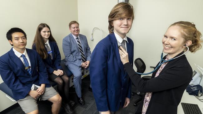 Billy Smith gets his blood pressure checked by GP Natasha Duncan as classmates Eden Dot, Lily Crittenden and principal Ross Bailey look on.