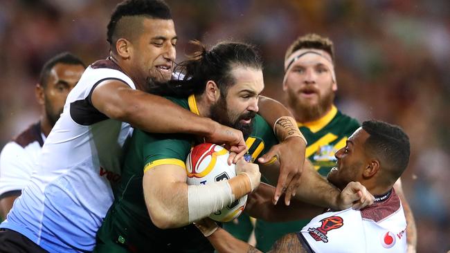 Kangaroos forward Aaron Woods is wrapped up by the Fiji defence.