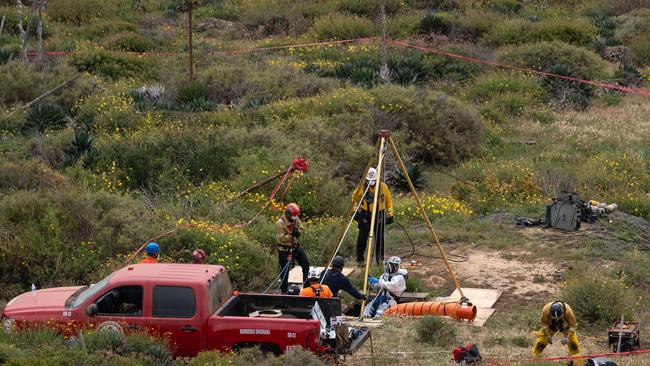 A rescue worker descends into a waterhole where human remains were found near La Bocana Beach. Picture: AFP