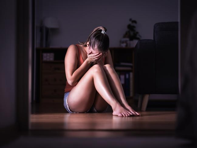 Victim of sexual harassment, domestic violence or abuse. Young sad woman crying and sitting on the floor at home. Ashamed, scared or lonely lady suffering emotional pain. Stress, trauma or sorrow. istock image