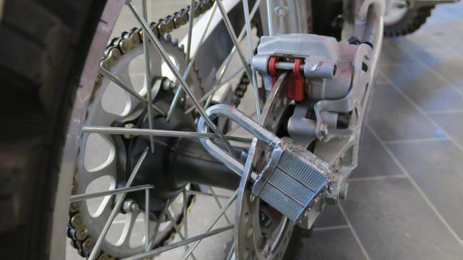 A damaged padlock and brake disc on one of the motorcycles.