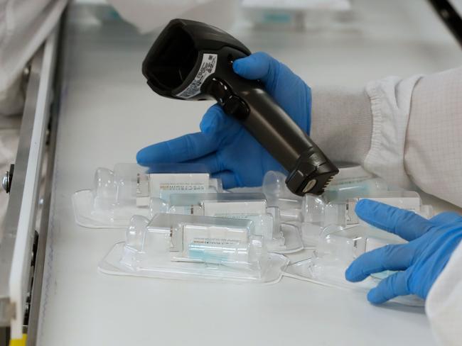 Workers assemble a saliva based, rapid result, collection kits to test for COVID-19. Picture: AFP