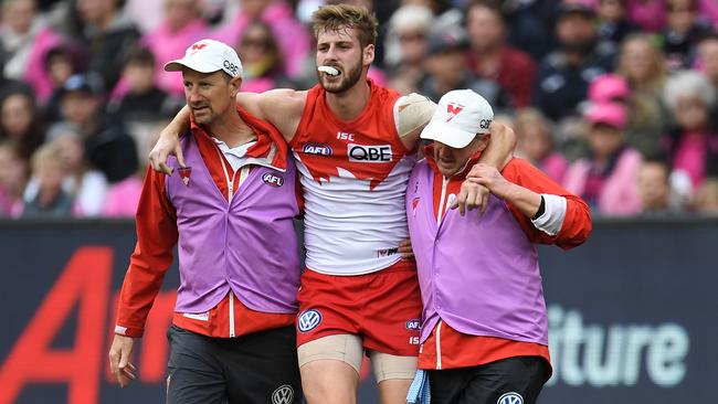 Johnson is helped from the field at the MCG.