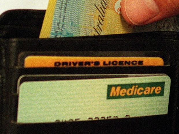 Mar 03, 2000 : Generic photo of man removing money from his wallet - notes Australian currency hand medicare card