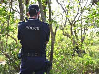 A policeman stands guard at the scene on the banks of the Pioneer River. Picture: Tony Martin