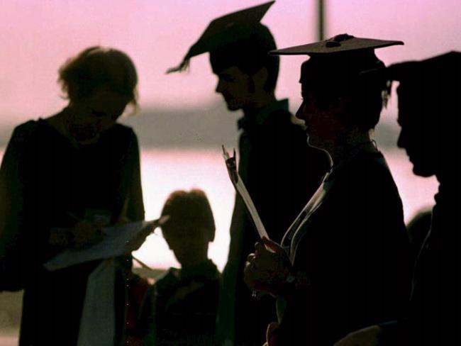 Silhouette of University students wearing graduation mortar boards and gowns during protest demonstration against education fees at Brighton Beach, England 01 Oct 1997. /Students/Tertiary