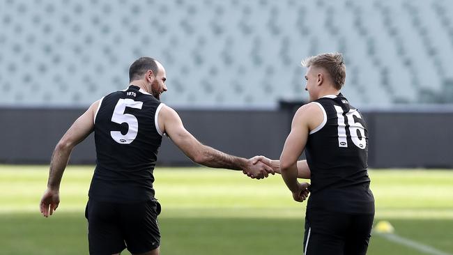 Matthew Broadbent makes a return to training after a lengthy injury - shakes the hand of Ollie Wines who has re-signed with the club for a further four years. Picture Sarah Reed