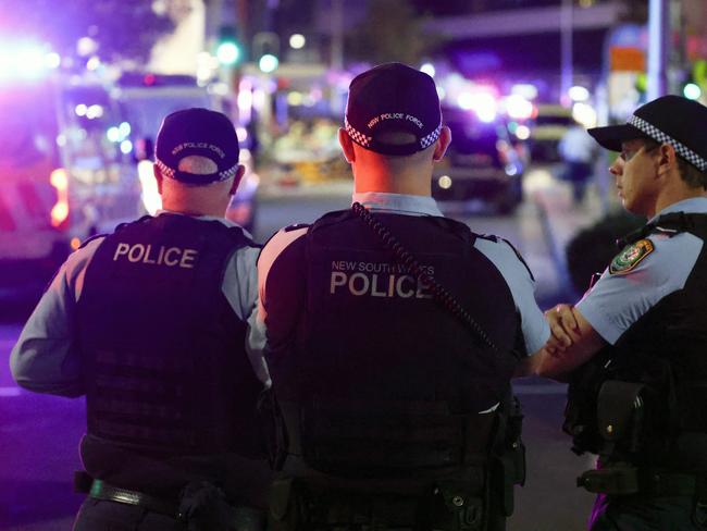 Police keep watch in front of the Westfield Bondi Junction shopping mall after a stabbing incident in Sydney on April 13, 2024. The number of people killed by a knife-wielding assailant in a Sydney shopping centre on April 13 has climbed to six, police said. (Photo by David GRAY / AFP)