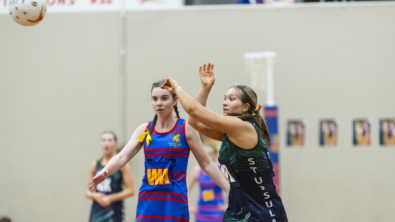 Emily Dolley (right) of St Ursula's Senior A fires off a pass against Downlands First VII in Merici-Chevalier Cup netball. Picture: Kevin Farmer