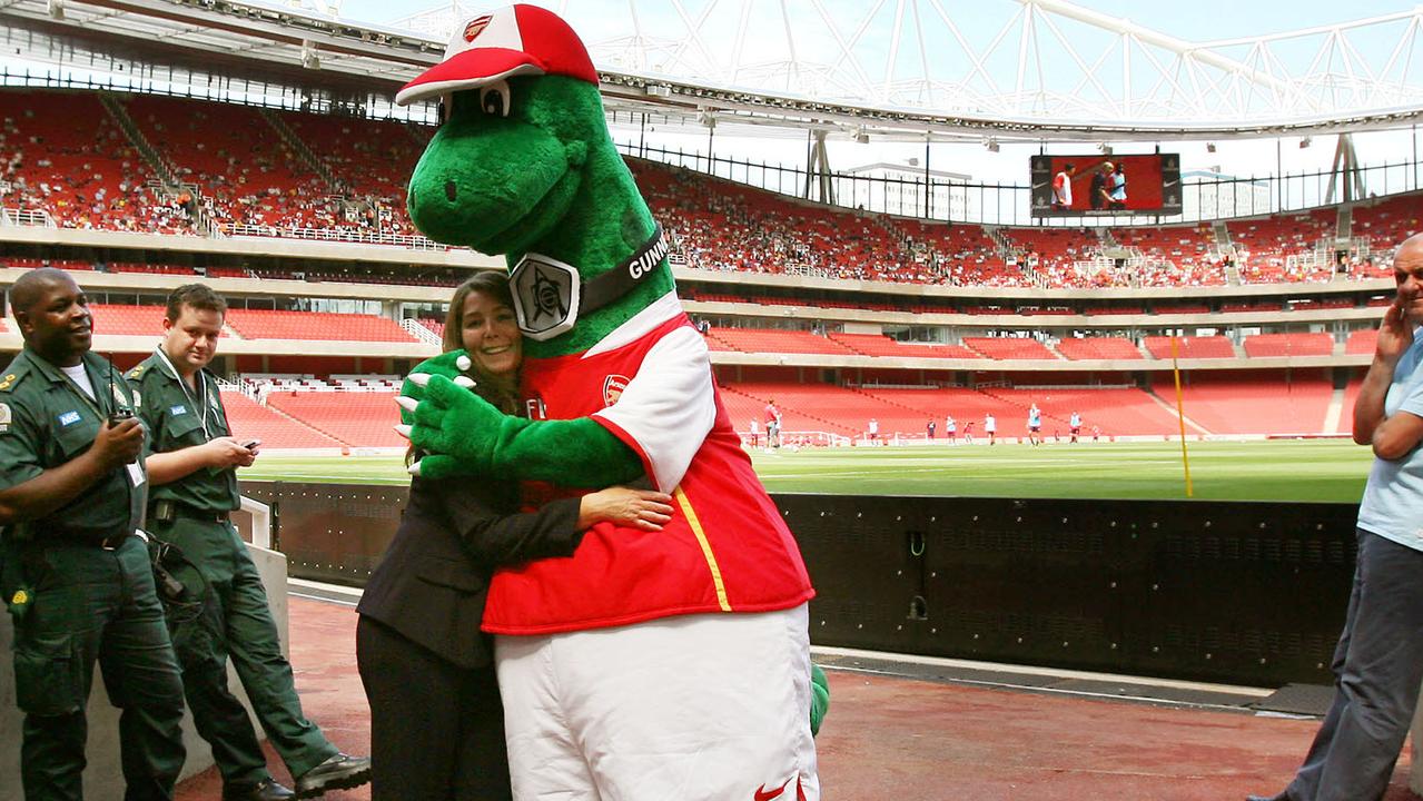 Gunnersaurus hugs an employee in the tunnel at the new Emirates Stadium in London. (Photo by Adrian DENNIS / AFP)