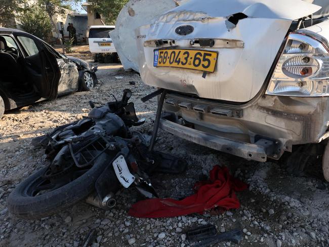 A motorcycle left behind by a Hamas militant lies next to a wrecked car in kibbutz Kfar Aza in southern Israel near the Gaza Strip on October 18, 2023. Picture: AFP