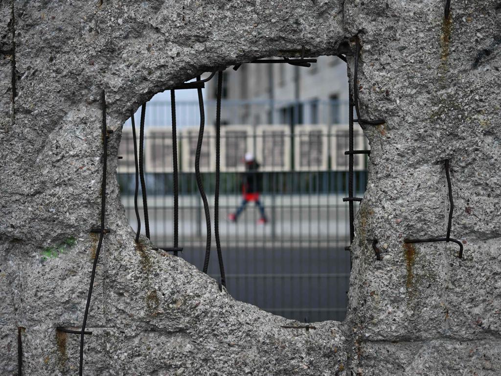 A pedestrian passes remaining parts of the Berlin Wall on October 3, 2024 — the 34th anniversary of Germany's Unification. Picture: AFP