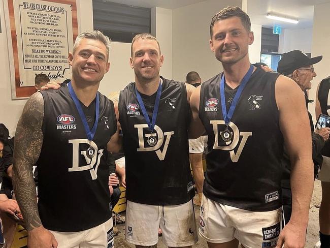 Dane Swan (centre) and Aaron Edwards (left) celebrate the flag with a teammate.