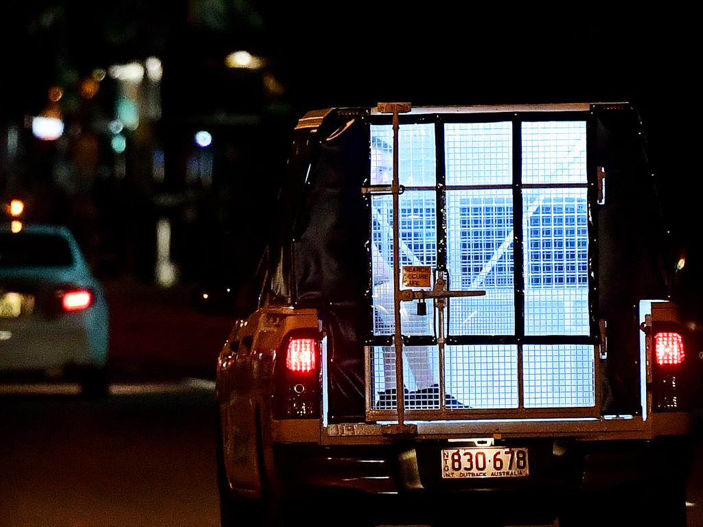 Police officers take away a reveller in a police wagon in the early hours of New Year's day