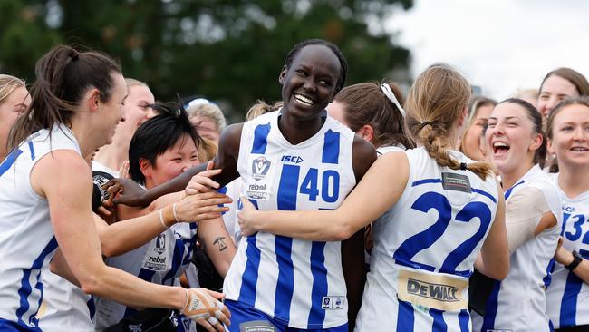 The Kangaroos celebrate as Nyakoat Dojiok is named best on ground. (Photo by Dylan Burns/AFL Photos)