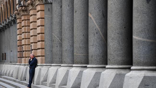 A man speaks on his phone in a deserted Martin Place in Sydney’s CBD. Picture: AAP