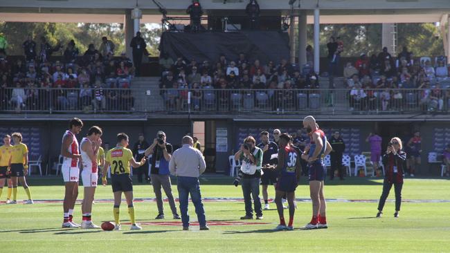 NT Treasurer Bill Yan (centre) tosses the coin at the Demons Saints game at Traeger Park, Alice Springs, June 1, 2025. Picture: Gera Kazakov