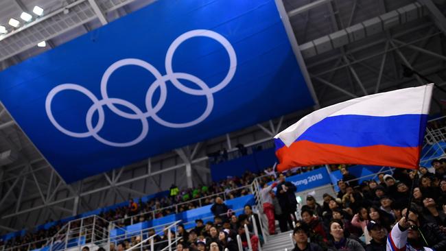 A spectator waves a Russian flag. Photo by Brendan Smialowski / AFP